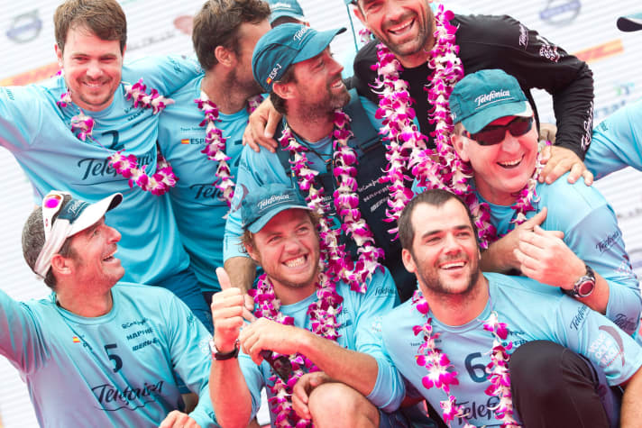   La victoire est belle : les marins de Telefonica avec le skipper Martinez (m.), Xabi Fernandez (chemise noire) et Andrew Cape (avec des lunettes de soleil) savourent le moment.