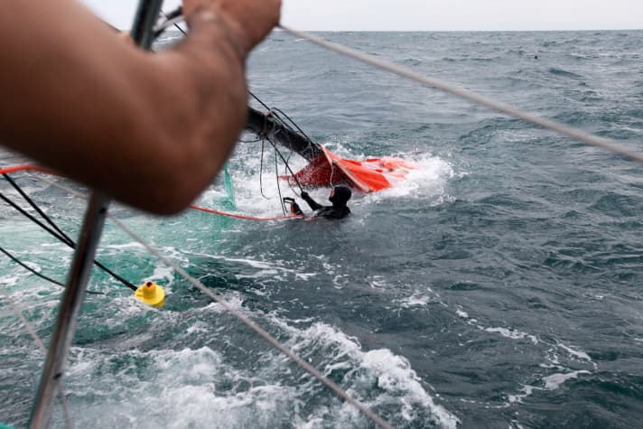   Man in the water: Groupama first had to recover the sails before the rig could be brought on board