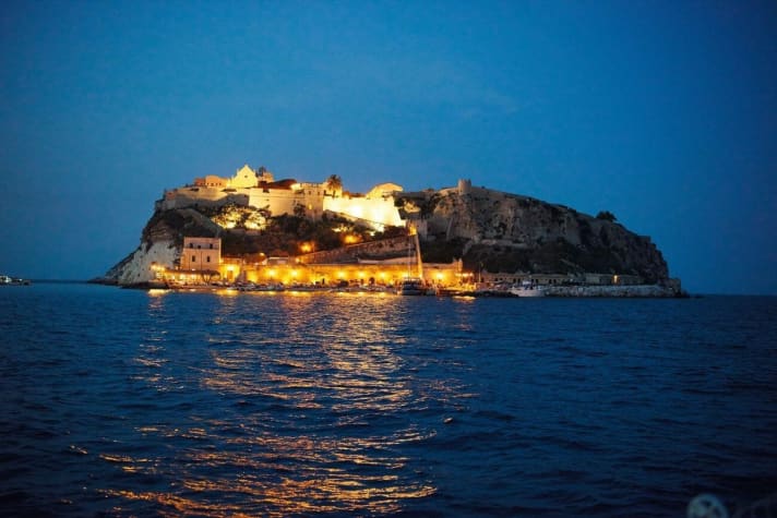   San Nicola am Abend. Hafen und der auf dem Felsen thronende Ort sind in gelbes Licht getaucht