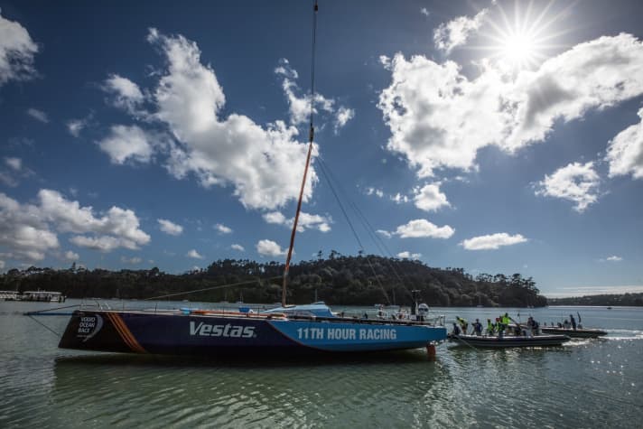   Ohne Mast und gut behütet wird das blaue Boot des Teams Vestas 11th Hour Racing nach der Reparatur in den Viaduct-Hafen von Auckland gebracht
