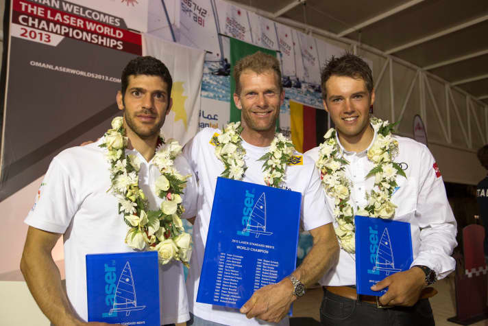   Le podium des championnats du monde de laser 2013 : Scheidt s'était alors imposé devant Pavlos Kontides (à gauche), qui a remporté les deux derniers titres mondiaux en 2017 et 2018 en laser. Le jeune Philipp Buhl, qui a remporté deux médailles de bronze et une d'argent aux championnats du monde 2013, a décroché la médaille de bronze lors de la finale et est plus qu'impatient de remporter son premier titre mondial.