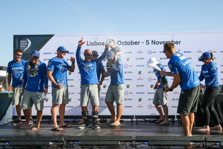   Champagne shower for the "blues": Charlie Enright's crew celebrates the successful kick-off in Lisbon