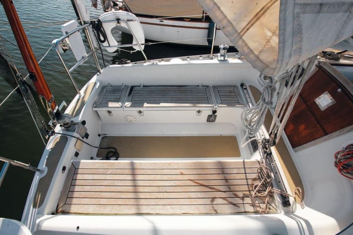   Dans le cockpit, il y a de la place pour quatre, même en navigation. En position couchée, la coque est également un siège confortable. Le barreur et le génois doivent partager la place. Le pont en teck est une pièce d'usure.