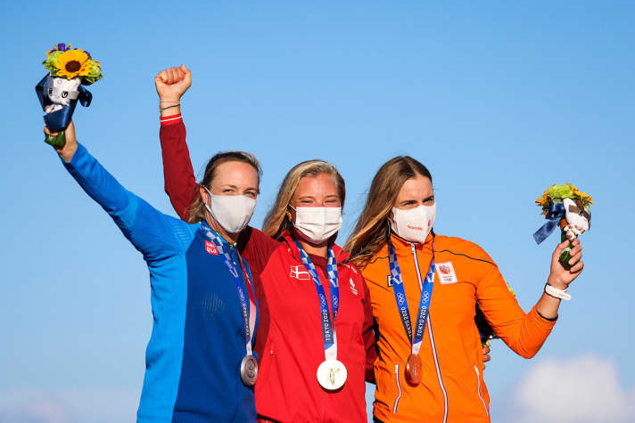   Le podium olympique de laser radial après une finale captivante : la gagnante danoise Anne-Marie Rindom, en larmes pendant des heures il y a deux jours suite à une erreur de sa part, rayonnait aujourd'hui avec le chaud soleil japonais et a offert aux fans d'Aarhus et de tout le pays une journée de soleil. La Suédoise Josefin Olsson a remporté la médaille d'argent, suivie de Marit Bouwmeester, qui a décroché le bronze, et qui peut ainsi se targuer d'avoir remporté une série rare de médailles, après l'argent en 2012 et l'or en 2016.