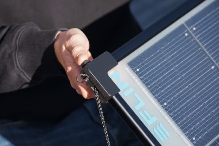   Die Fixierleinen dienen zum Ausrichten des Paneels, sie werden in Automatikklemmen gehalten, und das überschüssige Seil verschwindet per Gummizug im Rahmen