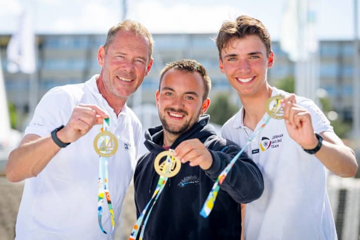   Drei der vier deutschen Kieler-Woche-Sieger (v.r.n.l.): Ole Schweckendiek, Adrien-Paul Farien und Heiko Kröger zeigen ihre Kieler-Woche-Medaillen. OK-Dinghy-Gewinner André Budzien fehlt