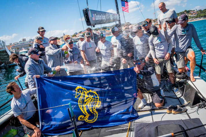   Les champions du monde de l'équipe Quantum Racing font sauter les bouchons et fêtent leur victoire.