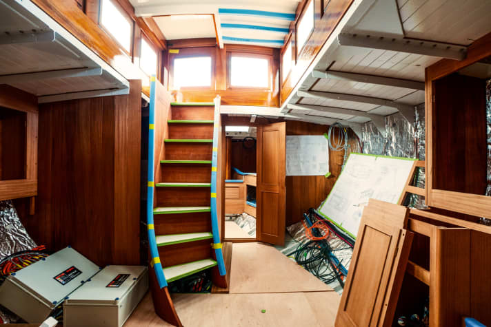 Marstal, Insel Ærø, Dänemark, DNK, 26.05.2022: Die 1920 aus Stahl bei Abeking & Rasmussen (A&R) gebaute Ketsch „Talisman“ von Klaus Sentker wird der Öffentlichkeit vorgestellt. Die Werft HCC Bådeværft KS (ehemals Ebbes Bådebyggeri & Sejlloft) von Monica Fabricius saniert das Schiff. „Talisman“ liegt an der Kaimauer. Innenaufnahme: Der Salon mit geschwungener Niedergangstreppe. Links Elektronik zum Torqeedo-Elektromotor. Im Hintergrund Blick durch die offene Tür in die Eignerkammer.

[ (c) Stefan Schorr. Größere Datenmenge auf Anfrage. Verwendung des Bildes nur gegen Honorar (nach aktueller MFM-Liste), Urhebervermerk (Stefan Schorr) und zwei Belegexemplare. Es gelten meine allgemeinen Geschäftsbedingungen unter www.stefanschorr.de/agbs/index.htm, mit dem Download dieses Bildes akzeptieren Sie diese. // Publication only with royalty payment (on basis of current MFM price list), credit line (Stefan Schorr) and two print samples. Please observe my terms and conditions of business at www.stefanschorr.de/agbs/index.htm, by downloading this image you agree to accept them. Anschrift / Postal Address: Stefan Schorr, Kattenescher Weg 65, 28277 B r e m e n. Telefon / Phone: +49 421 17225-95 (Fax -96), Mobil / mobile +49 1755221909, E-Mail: stefan@stefanschorr.de, homepage: www.stefanschorr.de. Konto / bank account: V o l k s b a n k  S t u h r, BLZ 29167624, Kto. 8180543800, SWIFT (BIC) GENODEF1SHR, IBAN DE27291676248180543800. USt.-Id-Nr. / VAT DE 230293095] [#0,26,121#]