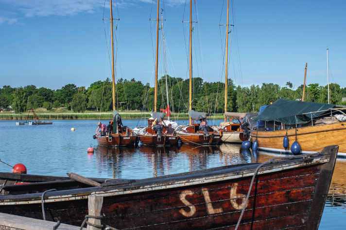 Wooden boats among themselves: the flotilla at the jetty of the museum shipyard in Saxemara