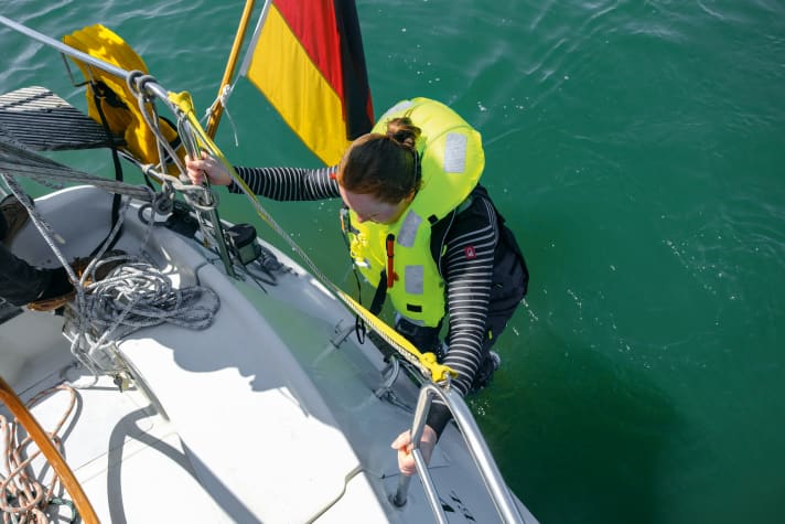 Se il membro dell'equipaggio è ancora in grado di salire sul ponte con le proprie forze, la scala da bagno è l'opzione più semplice. Utilizzare la cima per guidare l'infortunato verso la poppa. In caso di mare grosso, tuttavia, il beccheggio della poppa può essere pericoloso.