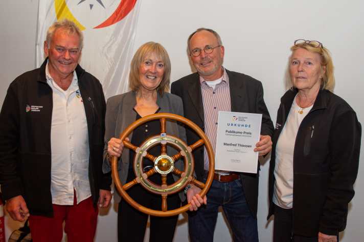 I vincitori del premio del pubblico per la migliore storia, i coniugi Thiessen (al centro) accanto alla presidente di DSV Mona Küppers (a destra) e al vicepresidente di DSV per la vela da crociera Claus Funk (a sinistra).