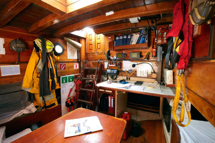Posto di lavoro. Tavolo da carteggio con radio e strumenti di navigazione nella rustica cabina del capitano