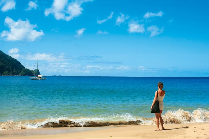 Angekommen. Claudia Clawien blickt vom karibischen Sandstrand der Pirate’s Bay von Tobago aus auf ihre dort vor Anker liegende stählerne Segelyacht „Inti“