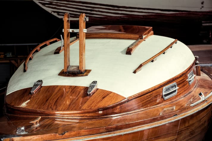 The dinghy cruiser has a varnished running deck made of solid mahogany and a cabin superstructure planked with softwood and then covered with canvas and painted white