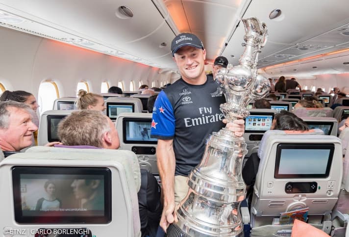   Preparation on the plane: Skipper Glenn Ashby carries the America's Cup through the ranks