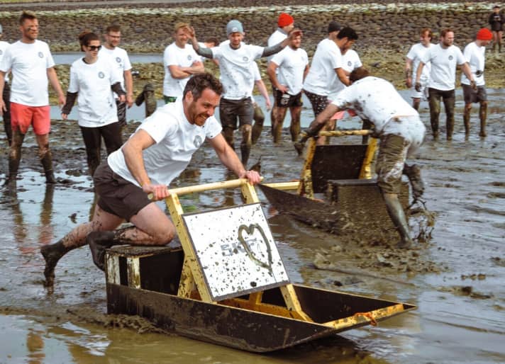 Racing across the mudflats: the sleds bore the logos of the main sponsors. Here Giovanni Berati from Damen Yachting shows his full commitment. | z.