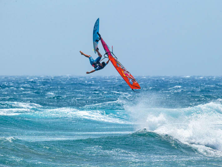 One-handed and one-legged: Philip Köster hangs relaxed in the air with the blue predecessor model of the V2 Impact Suit from Severne.