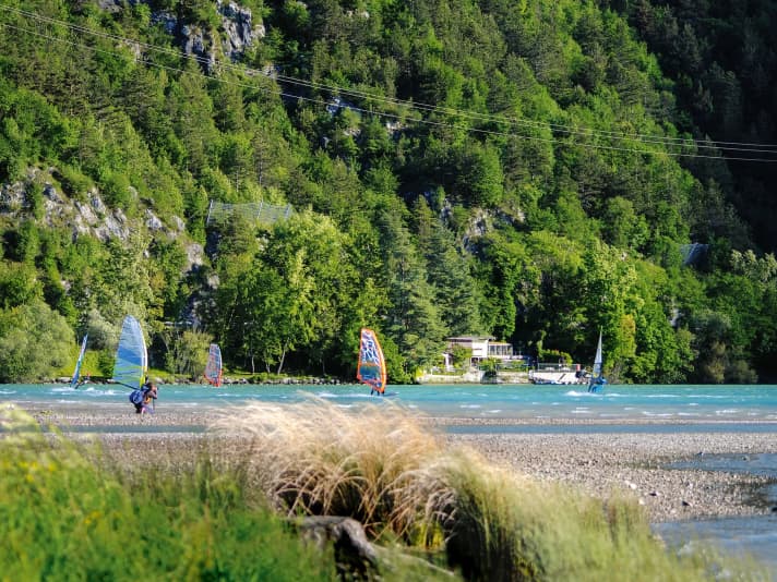 Five windsurfers in one picture on Lago di Cavazzo - it's like a rush hour on this idyllic lake.