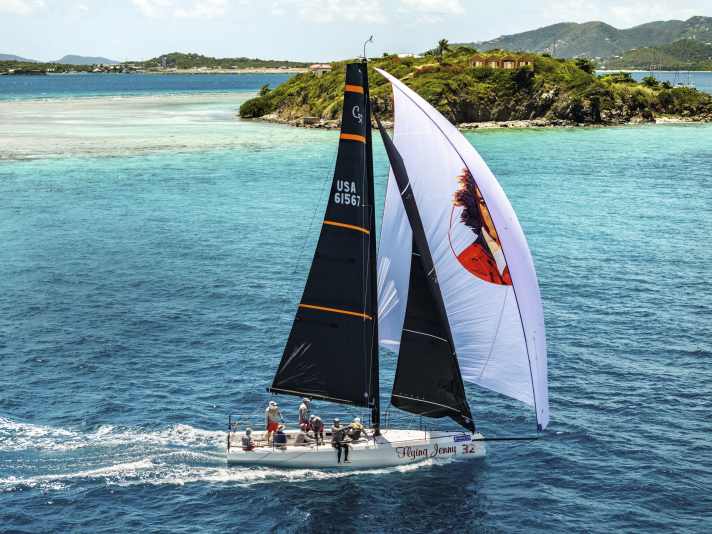 Picturesque finish: US owner Sandra Askew's Cape 31 "Flying Jenny" rushes past the eight-hectare island of Marina Cay under gennaker, main and jib, crossing the finish line of the Scrub Island Invitational race shortly afterwards.
race shortly afterwards. The fast Mark Mills design took just 2:18 hours to cover the twelve nautical miles from Nanny Quay.