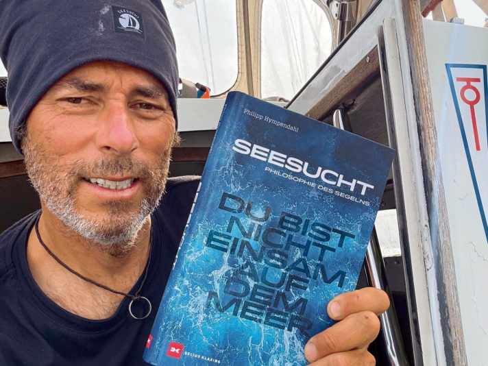 Solo and without harbour, round England/Ireland. portrait with book. photo: Philipp Hympendahl