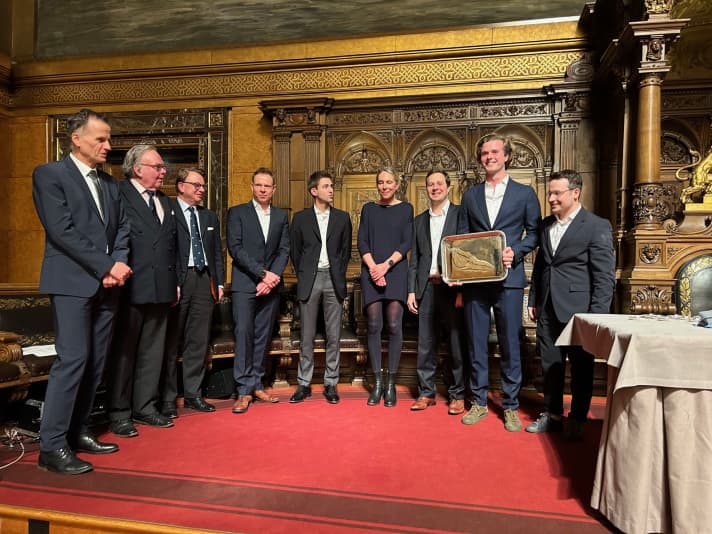 Die Crew der siegreichen “Red Bandit” mit dem German Offshore Award auf dem roten Teppich der Bühne im Großen Saal des Hamburger Rathauses