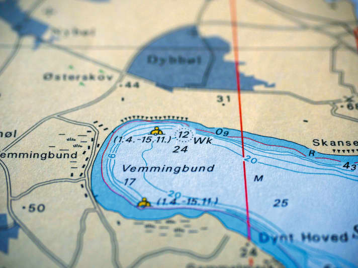 Consulter attentivement la carte marine permet d'éviter les mauvaises surprises. Avec un peu de chance, le type de fond marin est indiqué dans la baie en question. Il en va de même pour la nature des berges. Les falaises ou les zones forestières sont généralement également répertoriées. Pour les cartes officielles, la norme internationale « Carte 1 » définit l’apparence des symboles et des abréviations. Sur les cartes nautiques de plaisance, la notation peut varier, mais elle est alors généralement expliquée dans un livret d’accompagnement. Il convient en outre de prêter attention aux interdictions de mouillage, aux réserves naturelles, aux câbles et aux conduites.