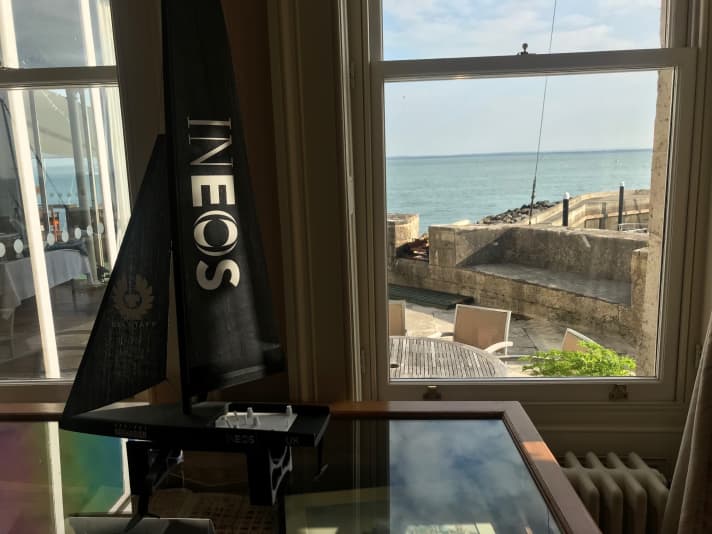   Gli ospiti di oggi al Royal Yacht Sqaudron di Cowes, sull'Isola di Wight: il team britannico Ineos Team UK e un piccolissimo modello dei sogni della Coppa d'Inghilterra alla finestra che si affaccia sul Solent.