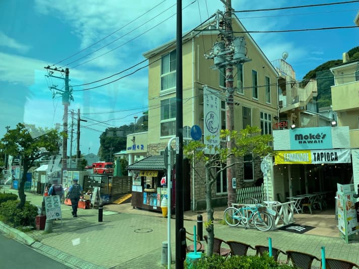   Les journalistes ne peuvent actuellement les voir que par la fenêtre du bus : Bâtiments, cafés et petites boutiques sur la route de desserte du port olympique