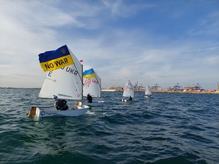   De jeunes navigateurs ukrainiens en Opti font un geste contre la guerre de Poutine lors de leur camp d'entraînement