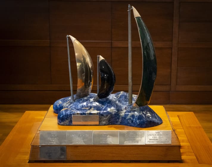 Come da tradizione, la Coppa di Sardegna, come la stragrande maggioranza dei trofei importanti, è soprattutto una cosa: brutta. E pesante, come gli equipaggi tedeschi hanno già imparato in occasione di tre cerimonie di premiazione.