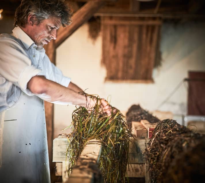 Dittmann breitet das gewaschene Gras zum Trocknen aus