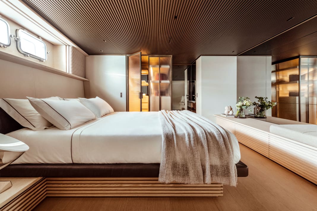 Owner's cabin: warm light streams out of the wardrobe through ribbed glass doors. Mirrors and wooden louvres extend the length of the room