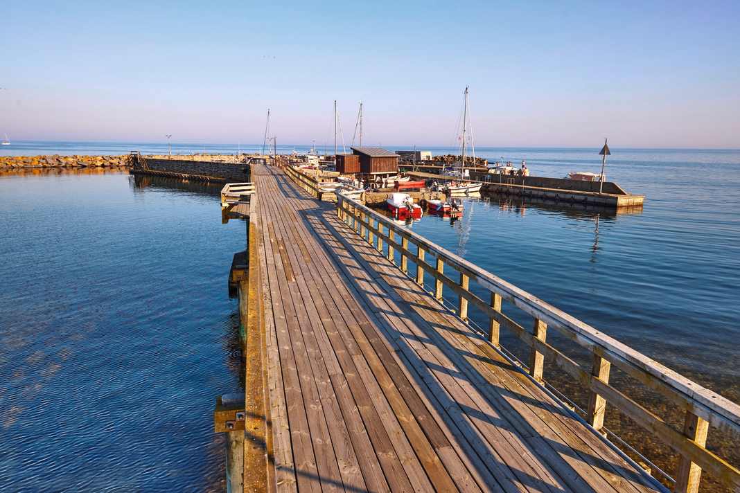 Il porto di Snogebæk, uno dei più piccoli di Bornholm, è collegato al villaggio e alla spiaggia sabbiosa da un molo di legno.