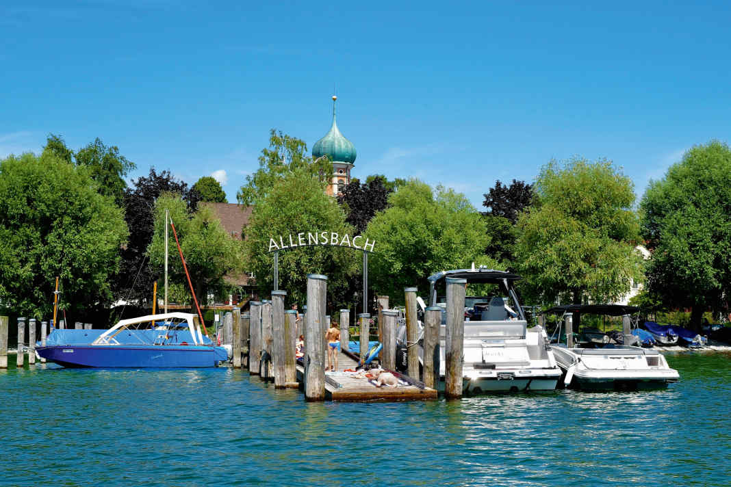 On the north bank in Allensbach, the baroque onion dome of St Nicholas' Church peeps above the treetops. A small jetty in front of it