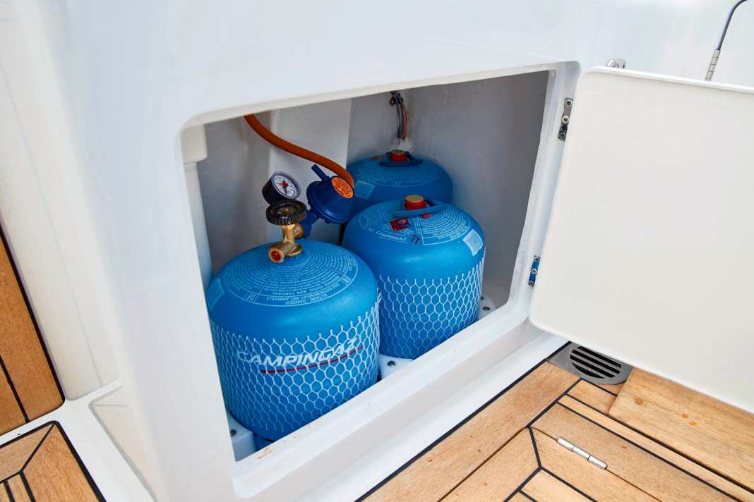 The regulator and the remote control solenoid valve are located in the gas locker. The orange sticker indicates a 50 millibar system and the line leads from the gas box to the outside via a bulkhead fitting.