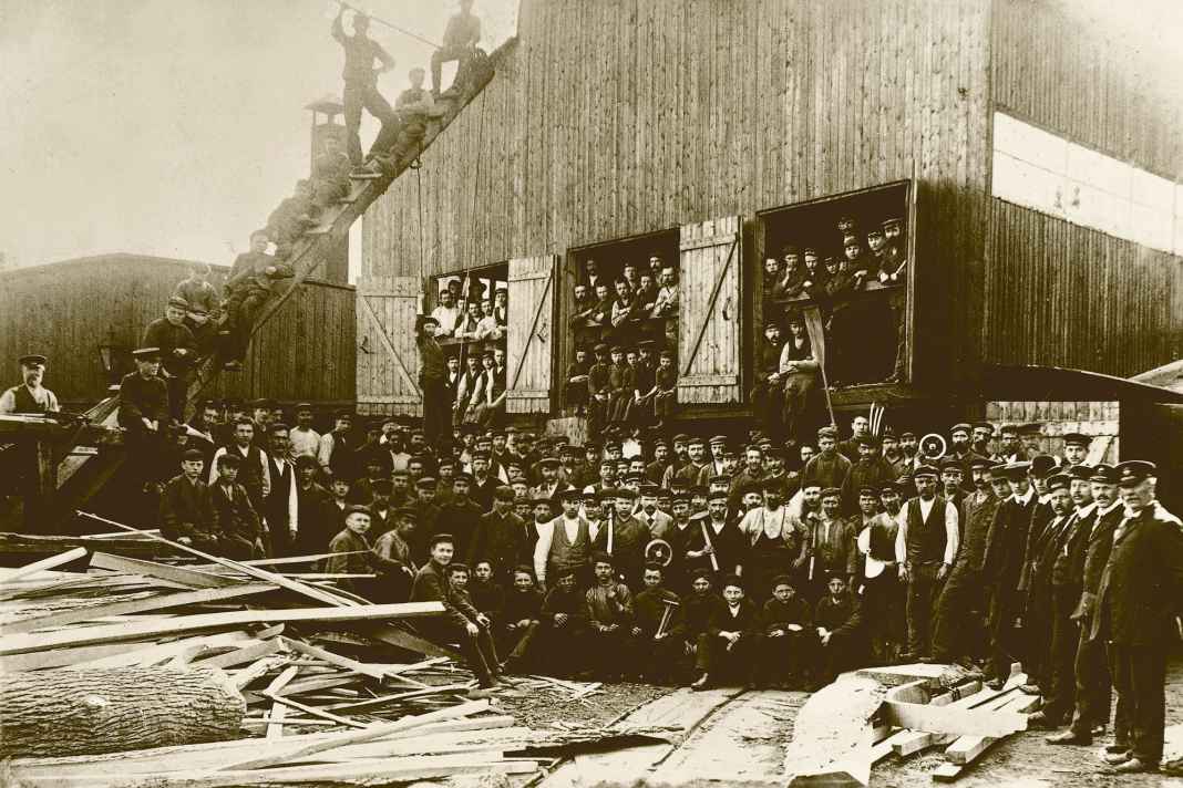 Great team: This photo was taken around 1910 and shows the Lürssen boatbuilders on the grounds of the shipyard in Bremen-Aumund.  At that time, rowing boats and motorboats were still being built here - out of wood.