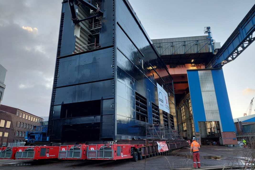 Eines der Schiebetore für die neue Brunsbütteler Schleusenkammer wird per Schwerlastmodul aus der Montagehalle gefahren.