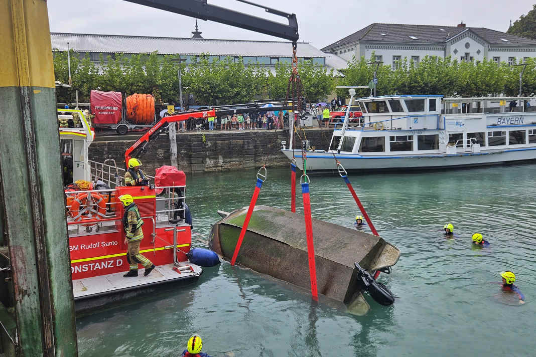 The capsized motorboat is being righted with the aid of a fire brigade crane.