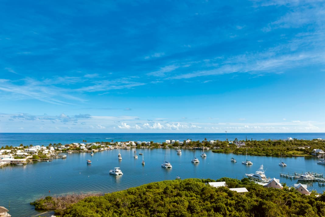 View of Hope Town Harbour from the lighthouse with the open Atlantic in the background. Our charter catamaran is bobbing on its mooring in the foreground of the picture