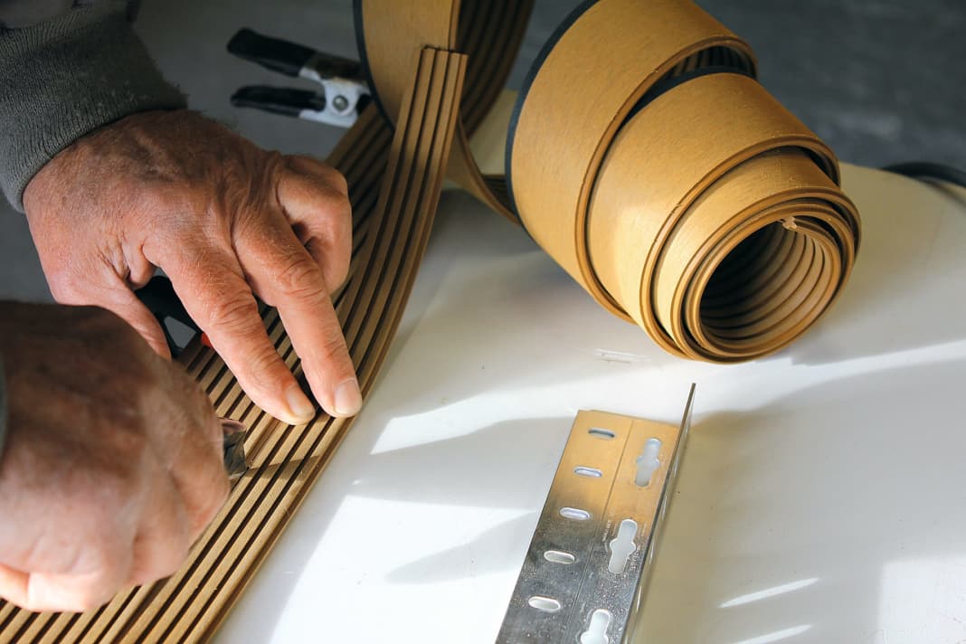 Interface: With a wooden boat like our Variant, there is no need for a template. Here, the strips cut with a cutter knife are "pinned" directly onto the deck. A ruler ensures that nothing goes wrong when cutting.
