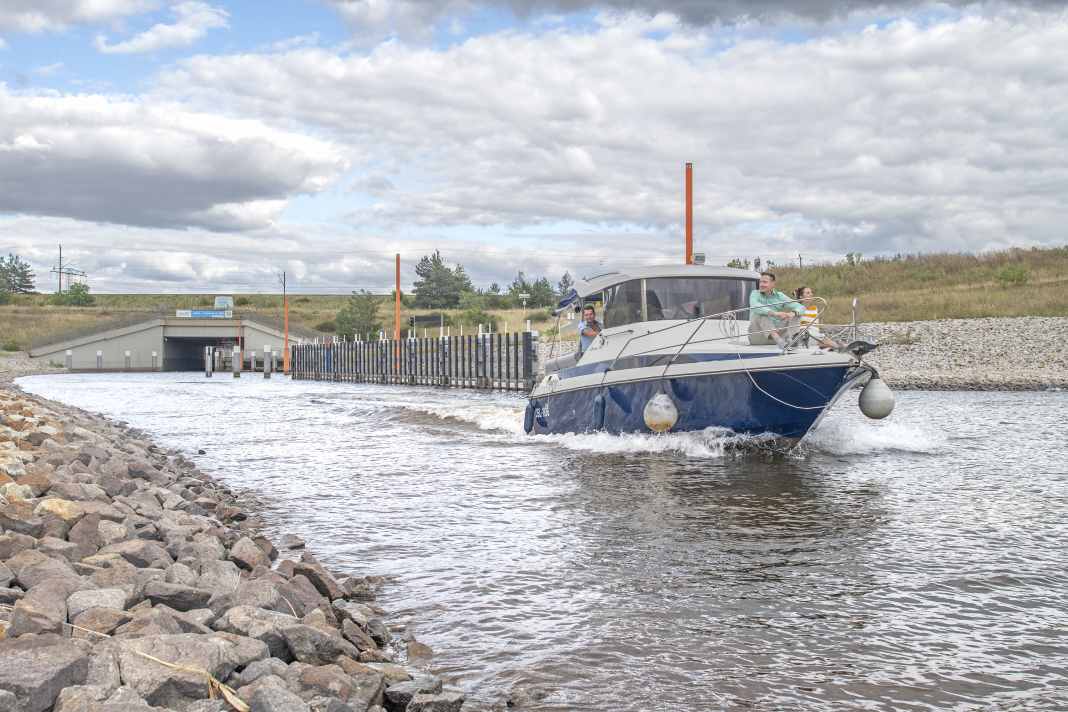 A motorboat is heading out of the Ilse Canal onto Lake Großräschen. The artificial waterway provides a navigable link to Lake Sedlitz.