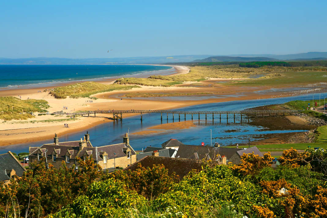 Lossiemouth an der Moray Coast: Blick über die Flussmündung auf die Dünen und den Strand von East Beach. Die Marina liegt links des Bildes mitten im Ort