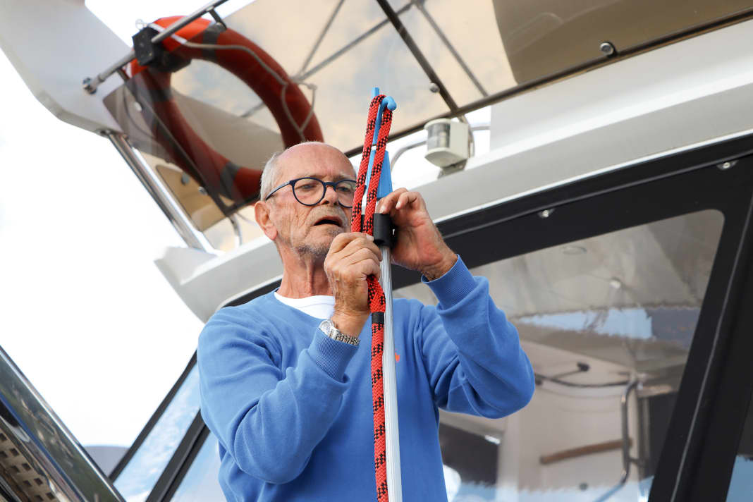 Das Auge der Leine wird über die Spitze des Bootshakens gelegt und mit dem unteren Ende des Auges in die Sail­matic-Klemme eingeführt