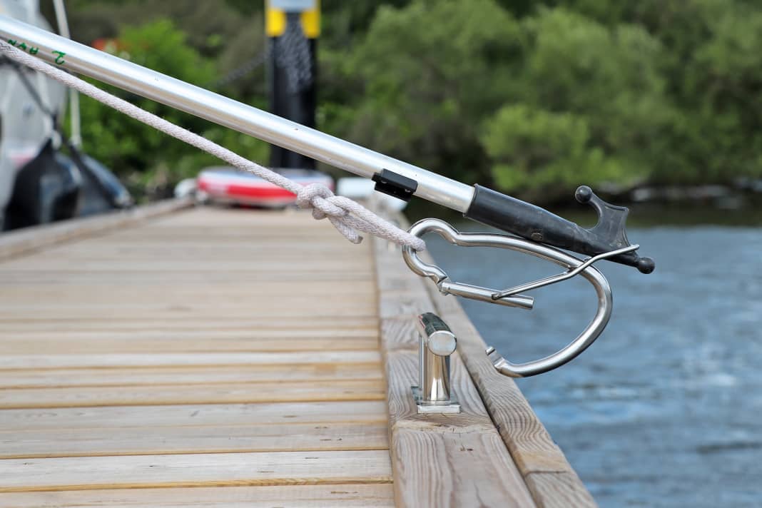 By simultaneously pressing with the tip of the boat hook and pulling on the knotted line, the carabiner opens and ...