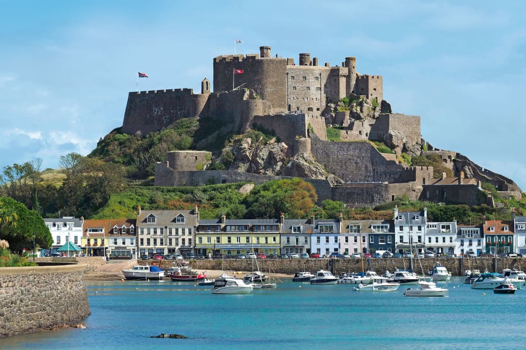 Jerseys älteste Burg Mont Orgueil Castle (um 1200 gebaut) mit dem Ort Gorey zu Füßen – eine beinahe mediterrane Postkartenidylle. Das Foto ist bei Hochwasser aufgenommen, bei Niedrigwasser fällt der Hafen vollständig trocken