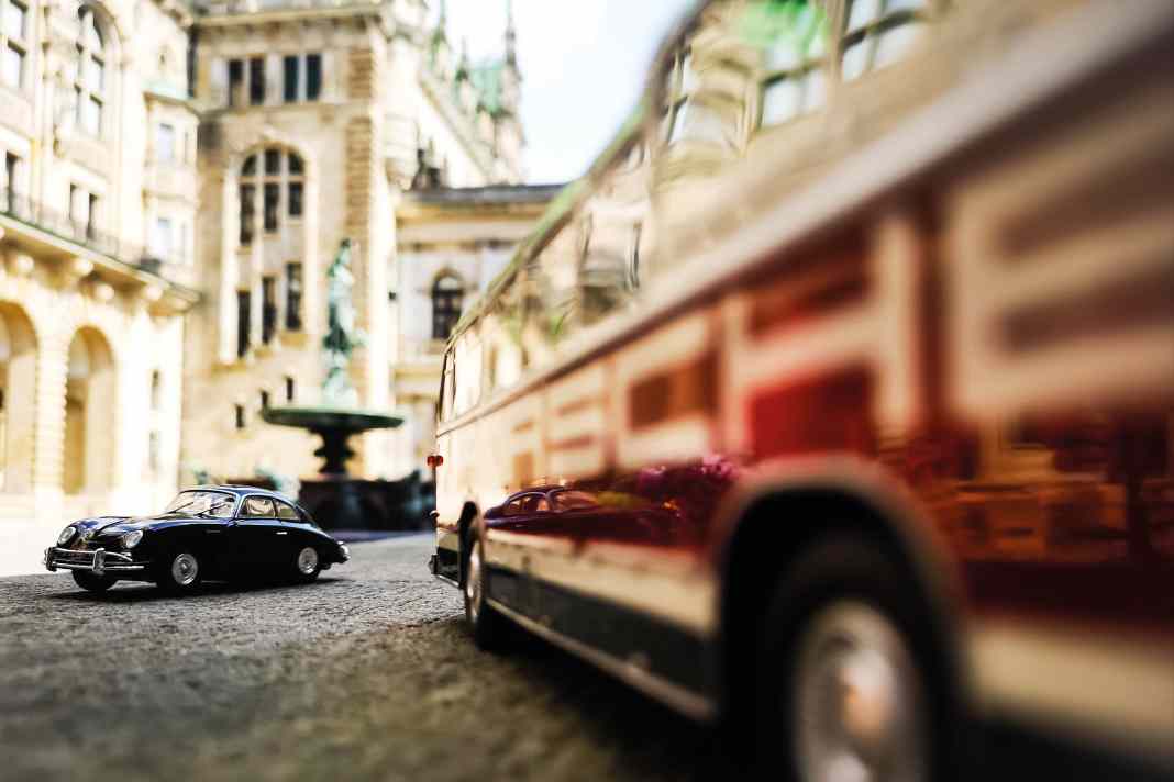Schick von Schuco: Im Innenhof des Hamburger Rathauses spiegelt sich ein Porsche 356 A Coupé im Lack des Neoplan-Busses FH11 »Porsche Renndienst«. Der Maßstab 1:43 scheint aufgehoben zu sein. Wir sind in der Zeit zurückversetzt etwa in das Jahr 1955.