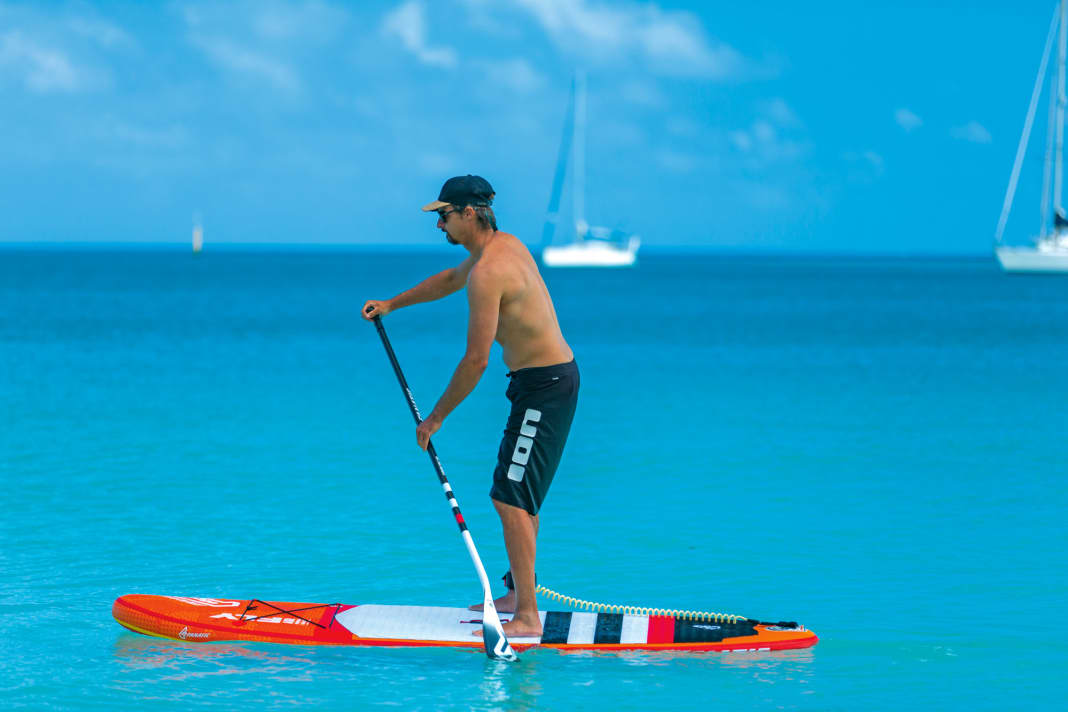 You pull the paddle out at the level of your feet or slightly in front of them, but not behind them, otherwise you switch to so-called negative paddling, which slows you down, destabilises you and can damage your back in the long run