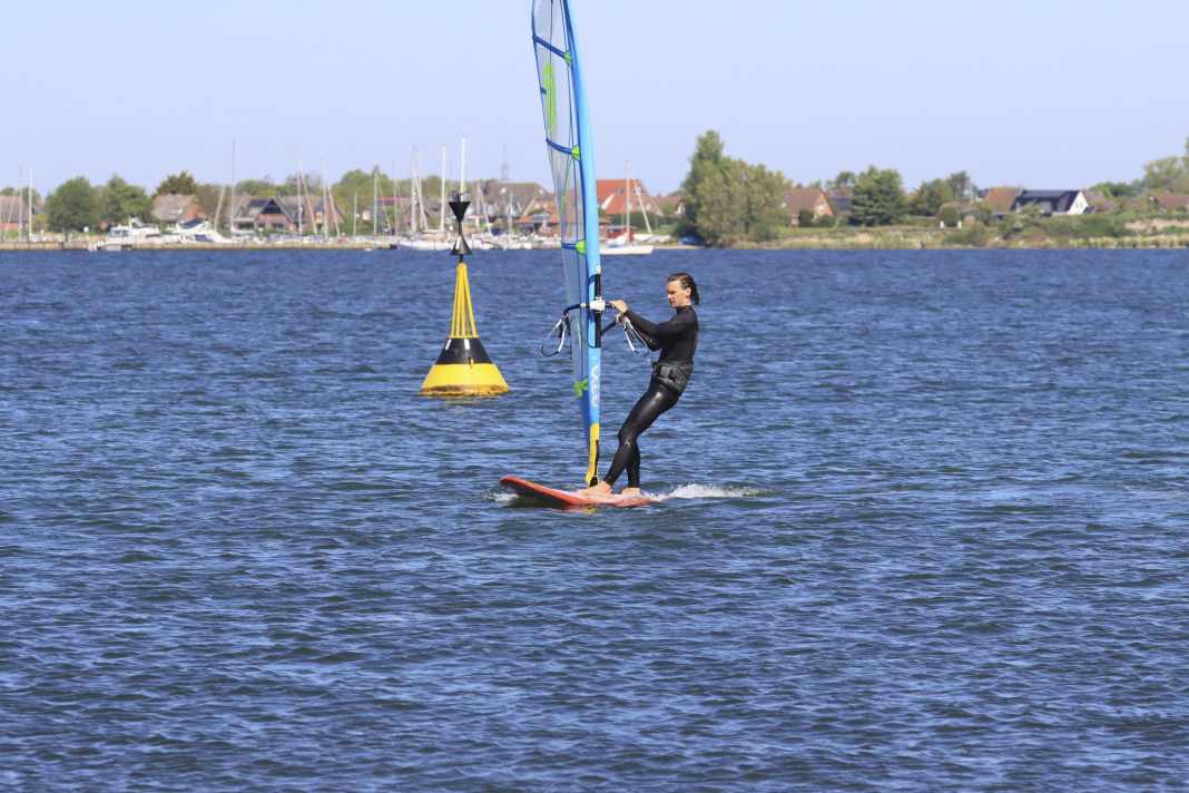 Initiate the following 180-degree turn to windward by luffing. In light winds, slide your back hand on the boom a little further forwards towards the mast - this way you can tilt the sail and still keep your upper body upright.