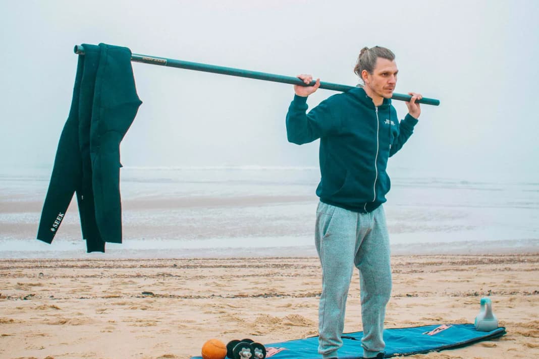No exercise trains more muscles in the body. The squat is still the most perfect exercise of all and should not be missing here either. But here I have a modified form for you. Take your pole and hang a weight on one end. I have used my Neo. You stand at the other end of the pole. Even if a wetsuit doesn't seem heavy at first, the leverage should not be underestimated and can still put a lot of strain on you because you now have to keep your balance and your entire core muscles have a lot to do.