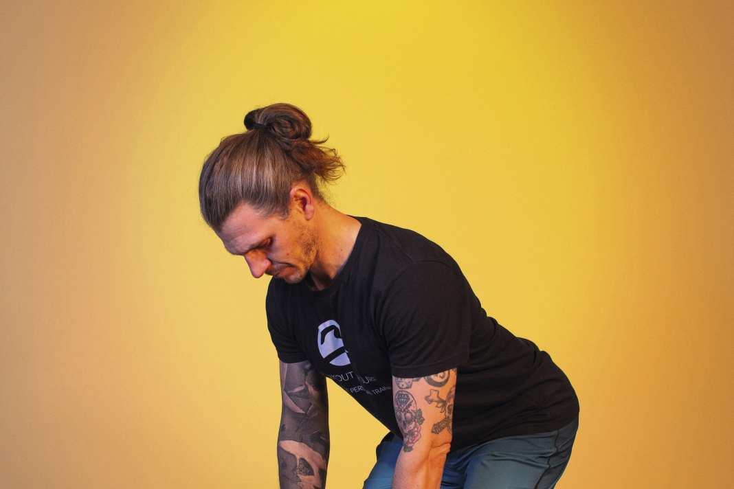 Bend forwards by tilting your pelvis back and bending your knees slightly. Keep your back straight and your chest proud. Let your arms dangle loosely downwards.